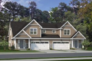 A two-story duplex with brown siding and white trim, featuring identical garages and front entrances. The homes are surrounded by trees.