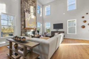 Spacious living room on Summertime Circle with high ceilings, stone fireplace, large windows, and modern neutral decor.