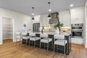 Summertime Circle kitchen: modern with island, barstools, pendant lights, stainless steel appliances, and wooden flooring.