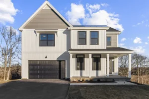 Modern two-story house on Summertime Circle with white siding, dark windows, and a single garage on a clear day.